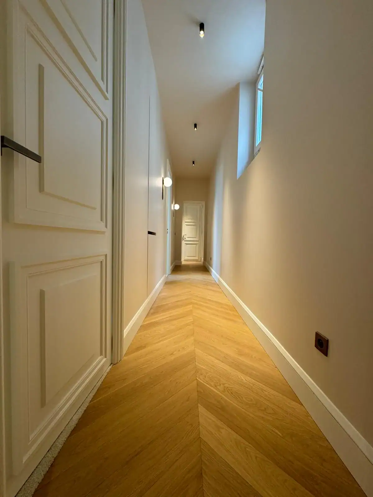 Couloir parquet chevron avec appliques globe et spots noirs — électricité Les Artistes